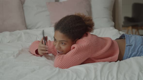 Cheerful African Woman Talking on Phone in Bedroom