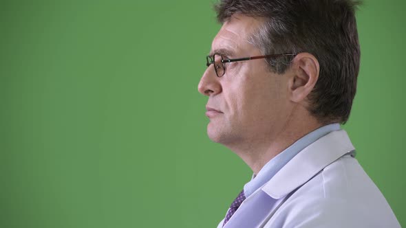 Mature Handsome Man Doctor Against Green Background