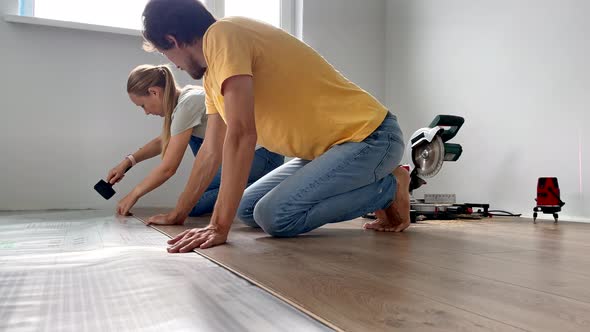 A Family of Woman and Man Install Laminate on the Floor in Their Apartment