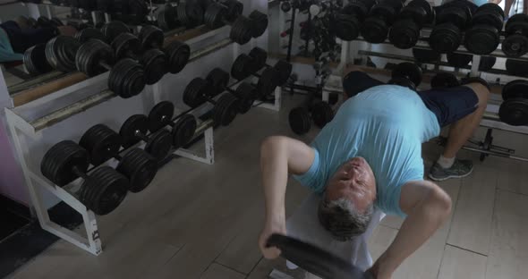 Mature man exercising with weight plate