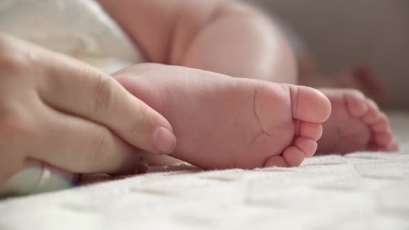 Mother Holding Baby Feet in Hands