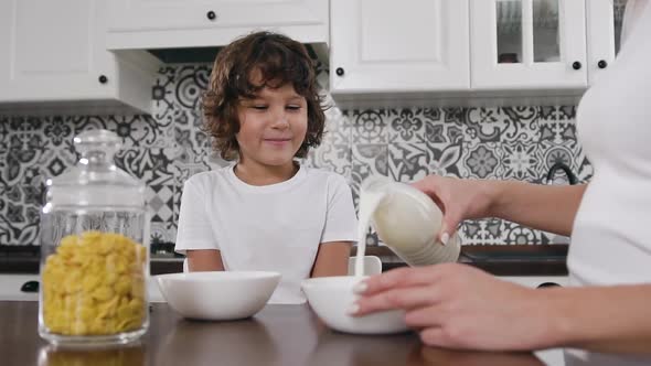 Smiling Boy Waiting Eagerly for His Healthy Breakfast with Flakes and Milk