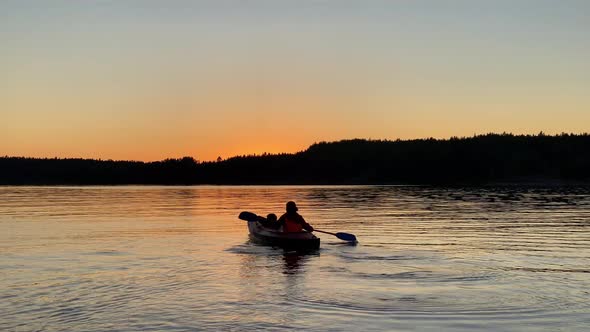 Silhouette of Person Rowing Kayak Along Tranquil Lake