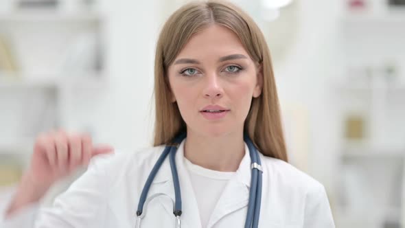 Portrait of Disappointed Young Doctor Showing Thumbs Down