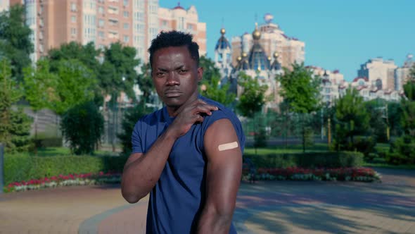 Afroamerican Man Patient Shows Medical Plaster Demonstrates Vaccine Injection