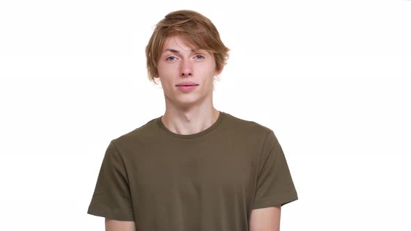 Portrait of Surprised Man Being Frightened Covering Open Mouth with Hand Staring Wideeyed Over White