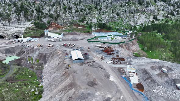 Heavy machinery drills tunnel through the mountain aerial view 4 K