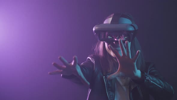 Anonymous woman in VR goggles in neon light
