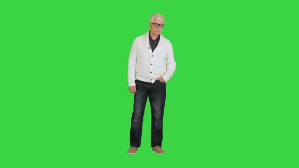 Happy Aged Man Shows a Greeting Sign on a Green Screen Chroma Key