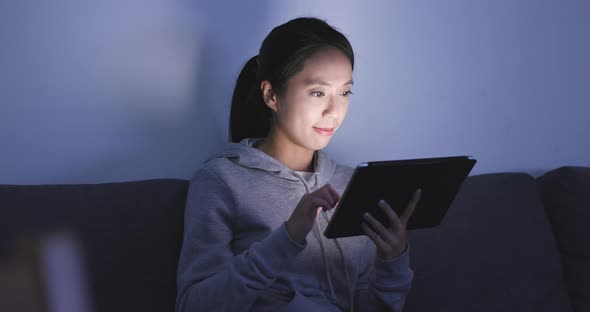 Woman watching on tablet computer at home