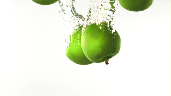 Super Slow Motion Whole Green Apples Fall Under the Water with Air Bubbles