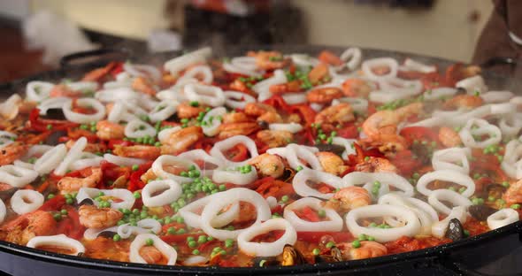 Chef Cooking Paella Rice Dish In Big Wok