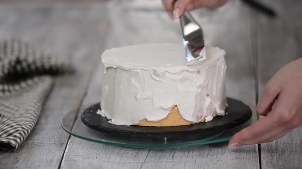 A Confectioner Prepares a Cream Cake. Dessert on a White Table in the Kitchen, The Concept of Home