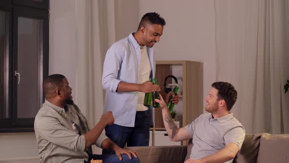 Male Friends Drinking Beer with Crisps at Home