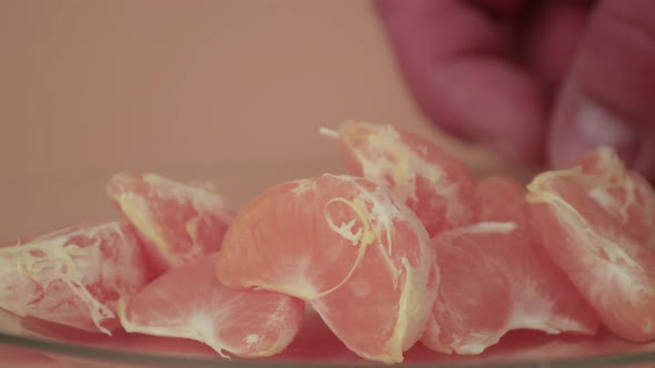 Closeup Male Hands Lay Out and Straighten Tangerine Slices on a Plate