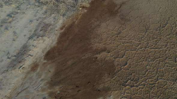 Fly over an old abandoned fisher boat on a dry dead sea ground, aerial shot