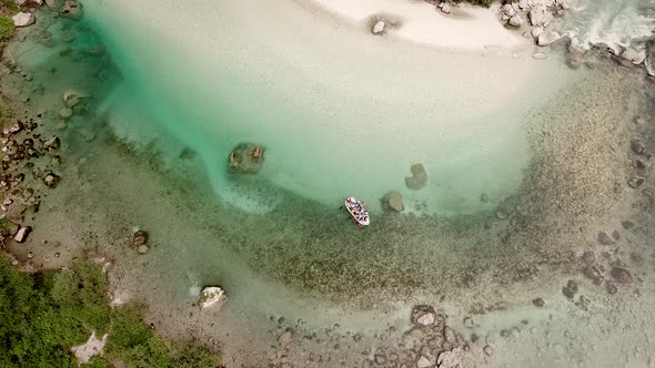 Aerial view of a group doing rafting in turquoise water of the Soca river.