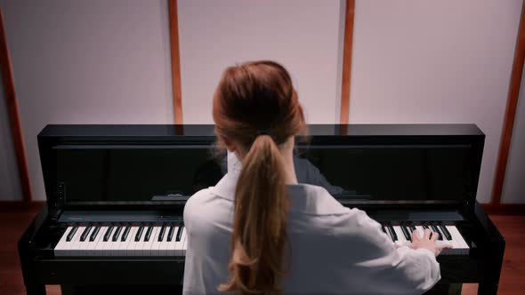 Woman sensually playing the piano view from the back