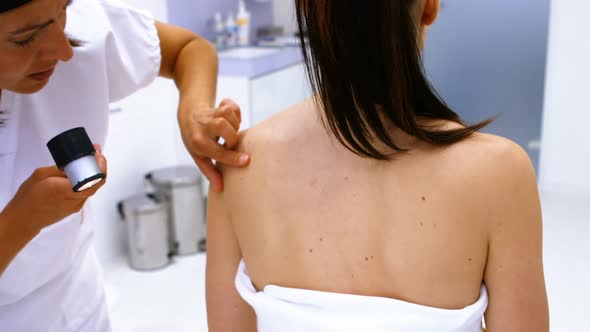 Doctor performing laser hair removal treatment on patient skin