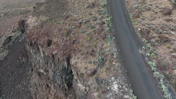 Aerial of a deserted road in a rocky desert terrain.