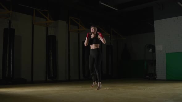 Female Fighter Trains His Kicks Training in the Boxing Gym Young Woman Looks at the Camera and