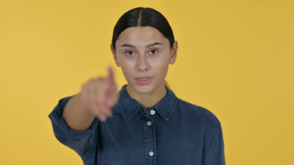 Latin Woman Pointing with Finger, Yellow Background 