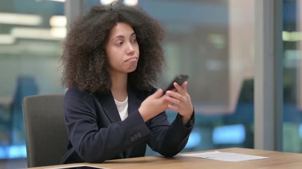 African Businesswoman Talking on Smartphone at Work