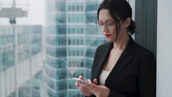 Portrait of a Business Woman with Glasses Using Mobile Phone.