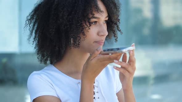 Beautiful African American Teen Girl Holding Mobile Phone, Talking on Speakerphone and Using Virtual