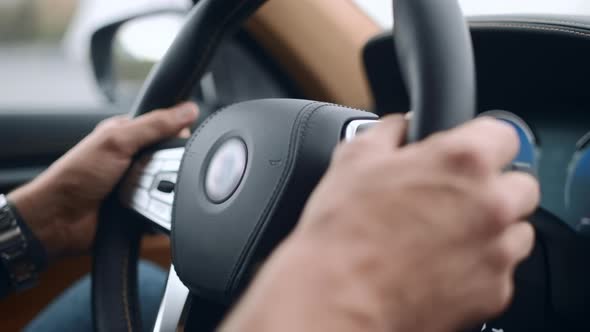 Closeup Male Putting Hands on Steering Wheel. Man Holding Steering Wheel at Car