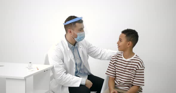 Male Pediatrician Giving a Vaccine Shot to a Black Kid