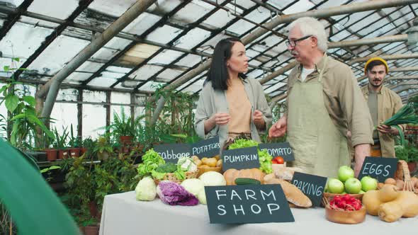 Young People Helping Elderly Man Selling Fresh Produce