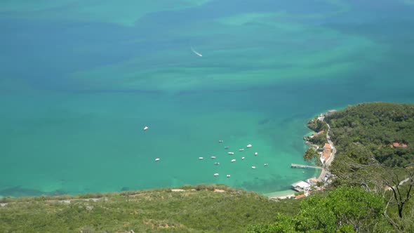 Boat Approaching The Beautiful Binaural Bay With Green Natural Landscape - Aerial Drone Shot