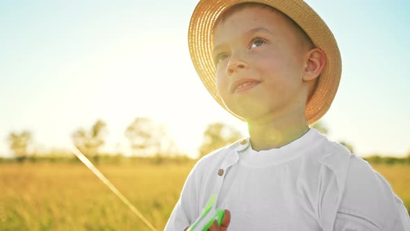 Close Up of Baby Boy Face Portrait in Panama Hat of Smiling and Happy Kid in Nature on Field with