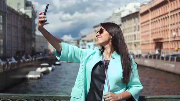 Smiling Tourist Stylish Woman Taking Selfie Using Smartphone Standing on Bridge Over River