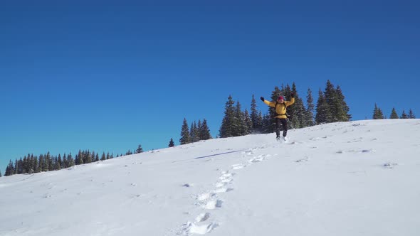 A Man with a Backpack Travels in the Mountains in Winter