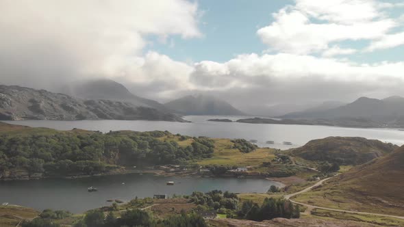 Aerial drone shot of beautiful scottish landscape in north highlands with lake bay and green mountai