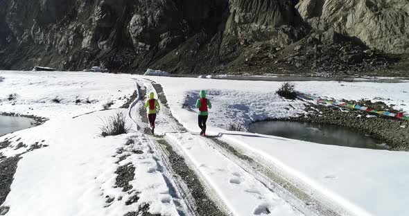 Two women trail runners cross country running in winter nature,Aerial view drone footage,slow motion