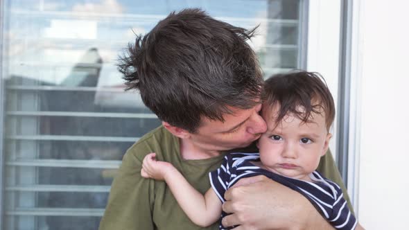 Closeup of a Baby in the Arms of His Father