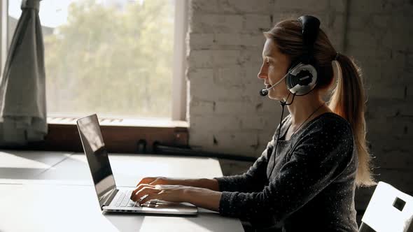 Focused Mature Woman Working in Call Center Using Headset