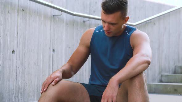 Young Man Touching Injured Leg