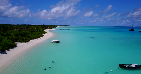 Wide fly over clean view of a white paradise beach and aqua turquoise water background in 4K