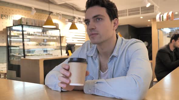 Young Man Drinking Coffee in Cafe