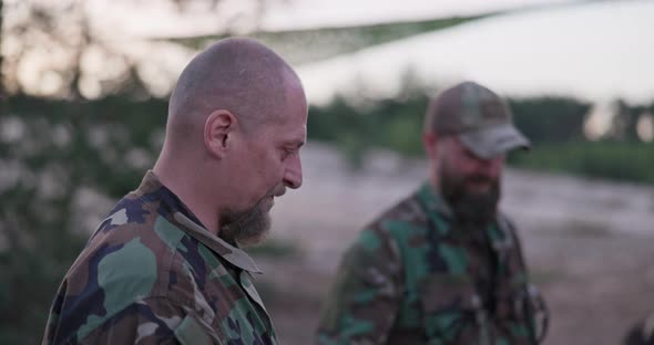 Conversation of Soldiers in Camouflage Clothes They are Discussing in the Evening By the Common