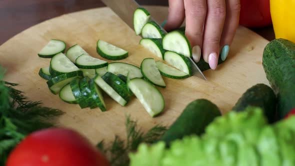 Closeup of Cook Cutting Fresh Cucumber on Wooden Chopping Board Slow Motion