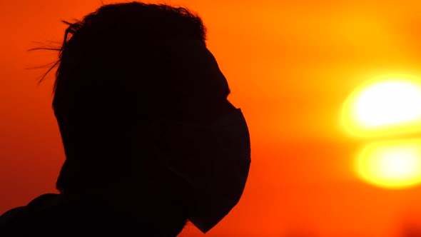 Portrait of Male in Surgical Protective Facemask, Side View. Silhouette of Pensive Male in Medical