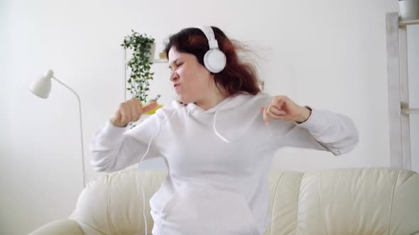 Happy Woman Listening To Music and Dancing in Living Room