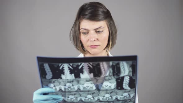 Young Female Nurse Reviewing Xrays Isolated on White Background