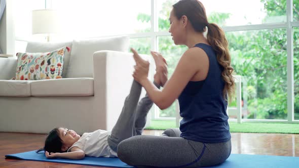 Asian Mother Practicing Yoga with Her Daughter