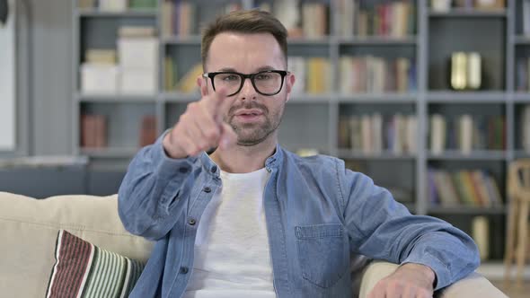 Portrait of Cheerful Young Man Pointing Finger at Camera